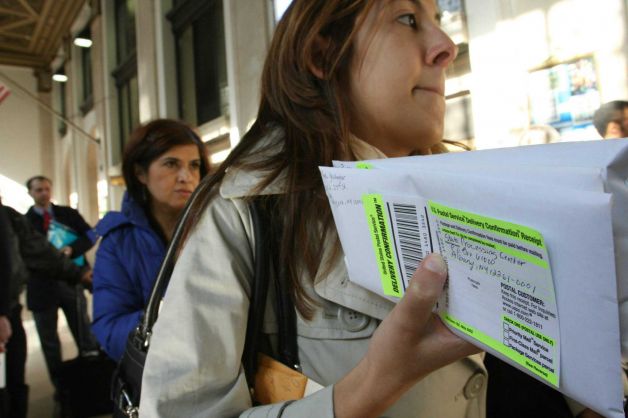 FILE - In this April, 15, 2008, file photo, Dana Pinero, of New York, foreground, waits in line to mail tax returns for both herself and her boyfriend at the James A. Farley Main Post Office in New York. The package of tax increases and spending cuts known as the �fiscal cliff� takes effect on January 1, 2013, unless Congress passes a budget deal by then. The economy would be hit so hard that it would likely sink into recession in the first half of 2013, economists say. Photo: Tina Fineberg / AP